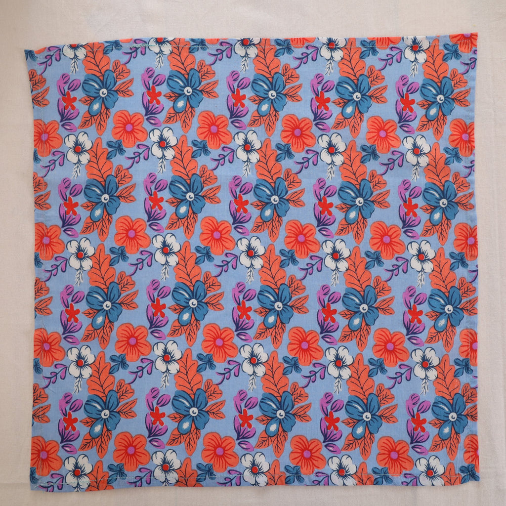 Blue and coral hand block print cotton napkin laid flat, full print visible