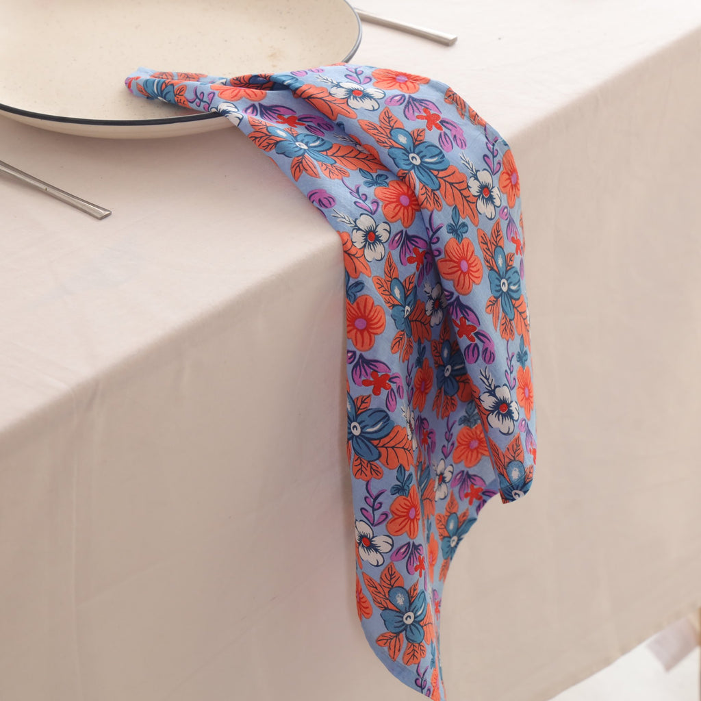 Blue and coral block print napkin draped over the edge of a table