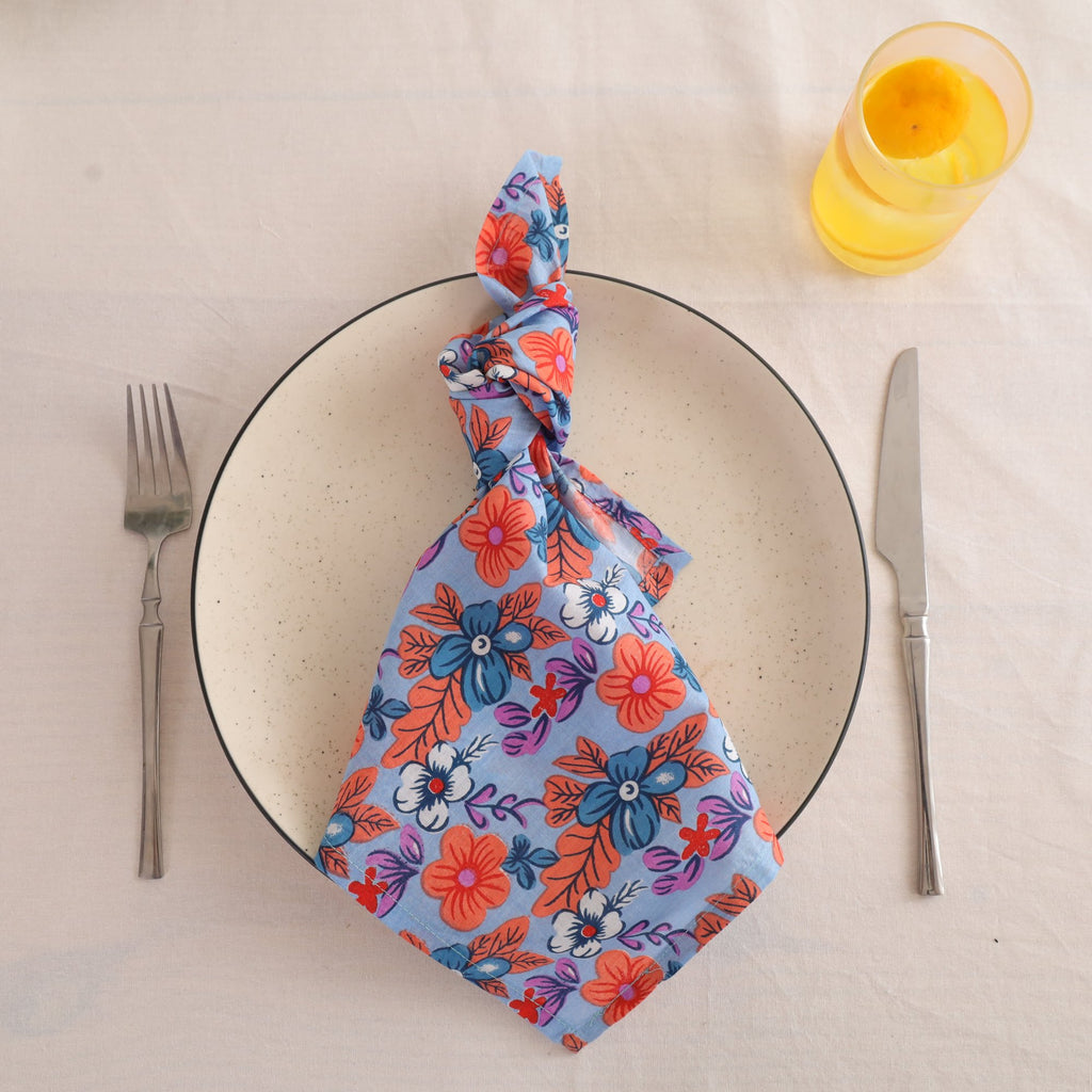 Blue and coral block print cotton napkin knotted on a plate