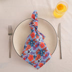 Blue and coral block print cotton napkin knotted on a plate