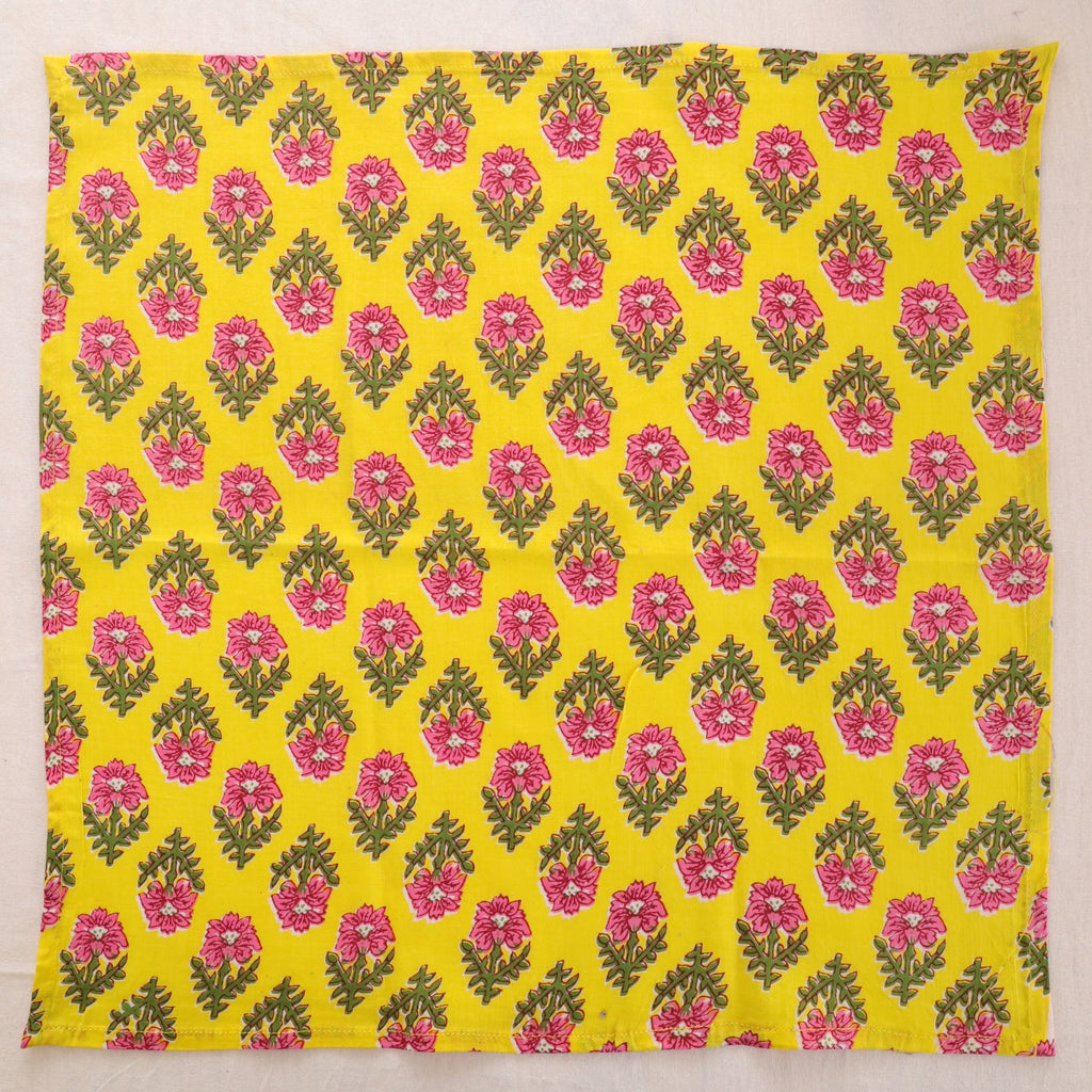 Yellow and pink hand block print cotton napkin laid flat, full print visible
