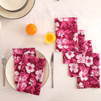 Set of four berry and white block print cotton napkins fanned out on a laid table