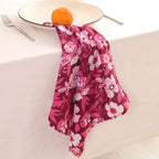 Berry and white block print napkin draped over the edge of a table