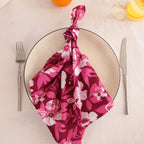 Berry and white block print cotton napkin knotted on a plate