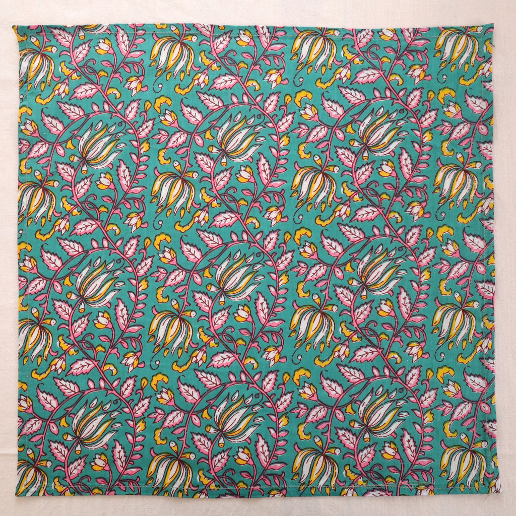 Teal and pink hand block print cotton napkin laid flat, full print visible