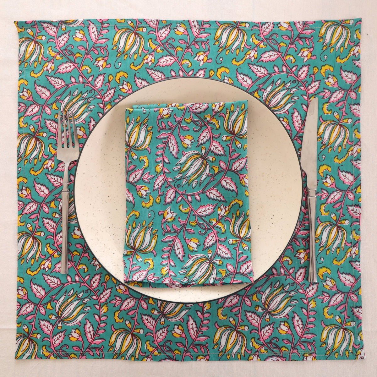Teal and pink block print napkin set as a place setting with plate and cutlery
