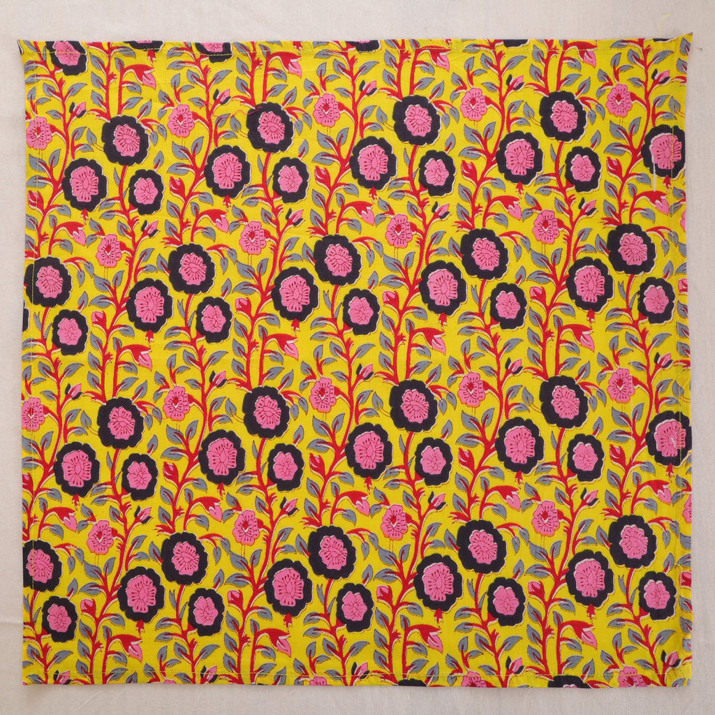 Chartreuse and pink hand block print cotton napkin laid flat, full print visible