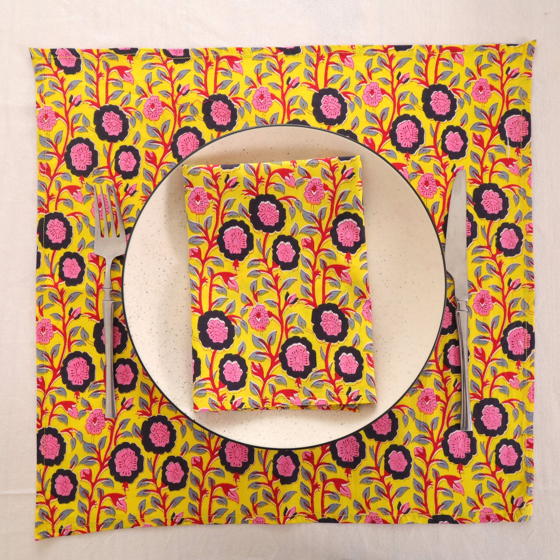 Chartreuse and pink block print napkin set as a place setting with plate and cutlery