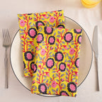Chartreuse and pink block print cotton napkin folded on a dinner plate