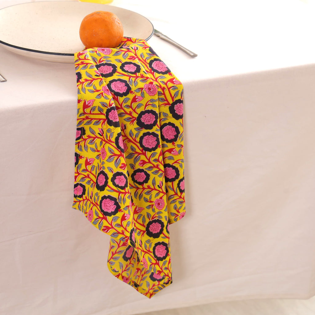 Chartreuse and pink block print napkin draped over the edge of a table