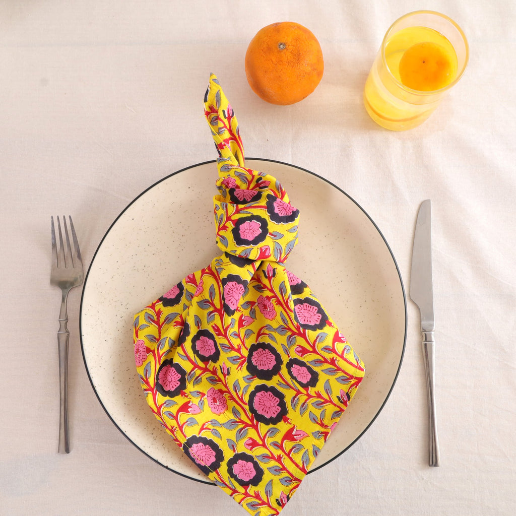Chartreuse and pink block print cotton napkin knotted on a plate