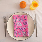 Pink and purple block print cotton napkin folded on a dinner plate