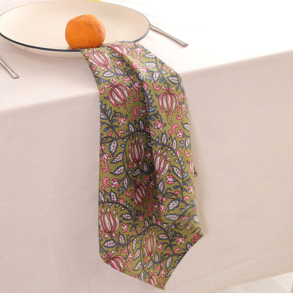 Olive and pink block print napkin draped over the edge of a table