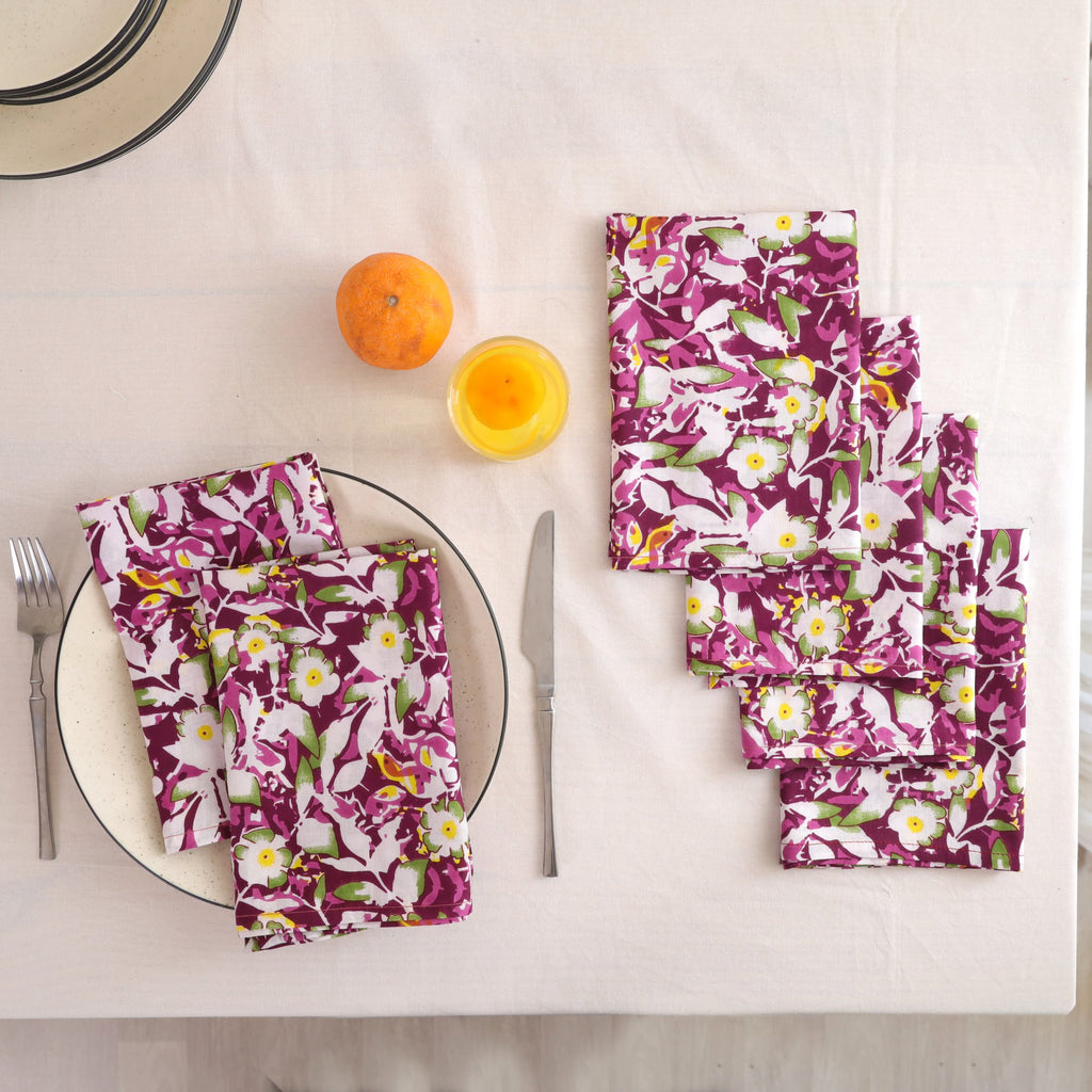 Set of four purple and white block print cotton napkins fanned out on a laid table