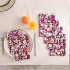 Set of four purple and white block print cotton napkins fanned out on a laid table