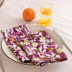 Purple and white block print cotton napkin folded on a dinner plate