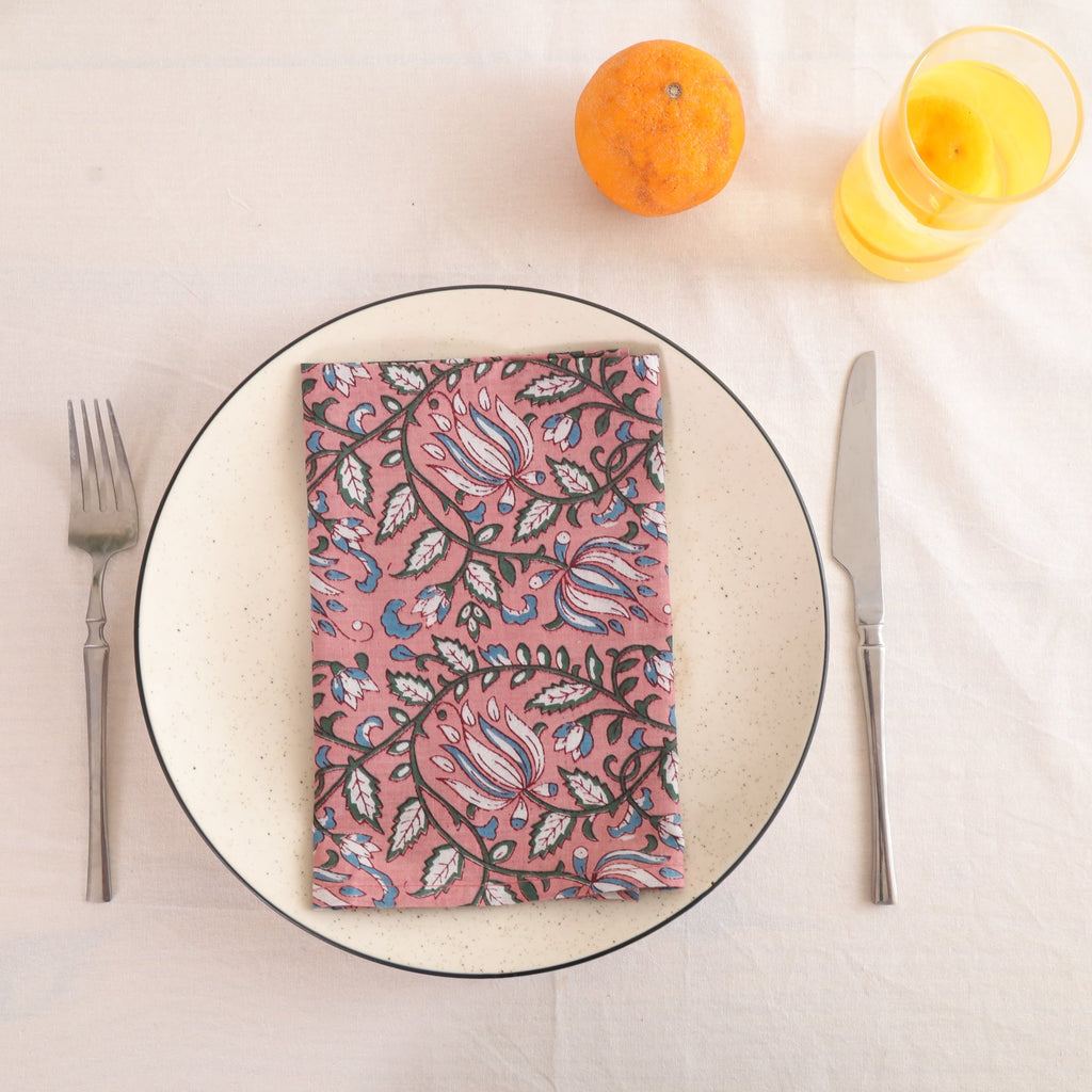 Dusty rose block print cotton napkin folded on a dinner plate