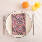 Dusty rose block print cotton napkin folded on a dinner plate