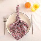 Dusty rose block print cotton napkin knotted on a plate