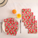 Set of four red and green block print cotton napkins fanned out on a laid table