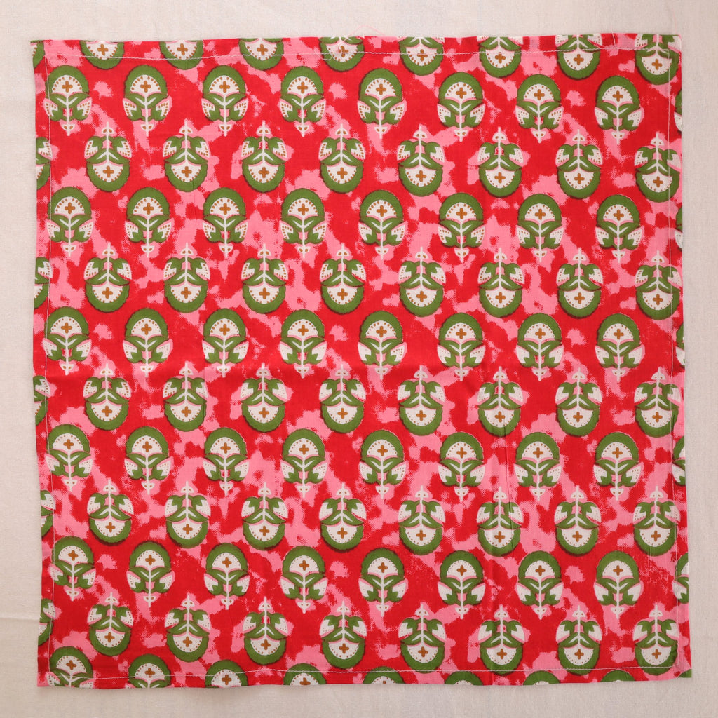 Red and green hand block print cotton napkin laid flat, full print visible