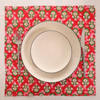 Red and green block print napkin set as a place setting with plate and cutlery