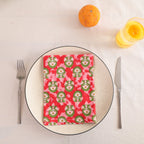 Red and green block print cotton napkin folded on a dinner plate
