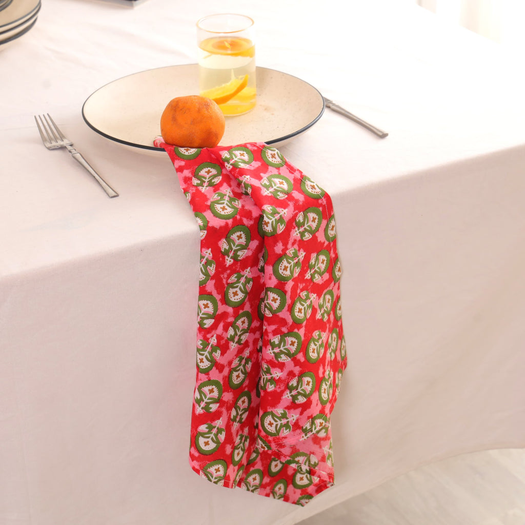 Red and green block print napkin draped over the edge of a table