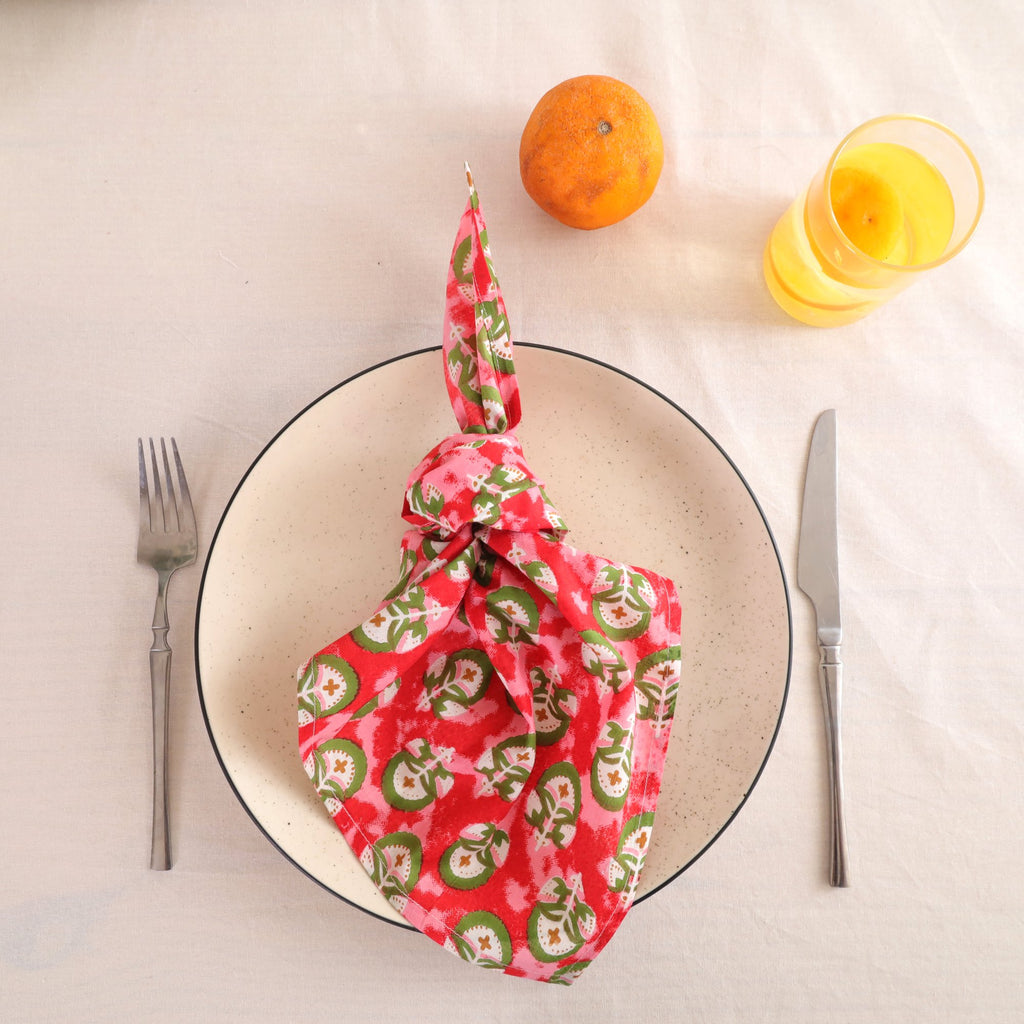 Red and green block print cotton napkin knotted on a plate