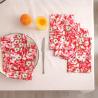Set of four red and cream block print cotton napkins fanned out on a laid table