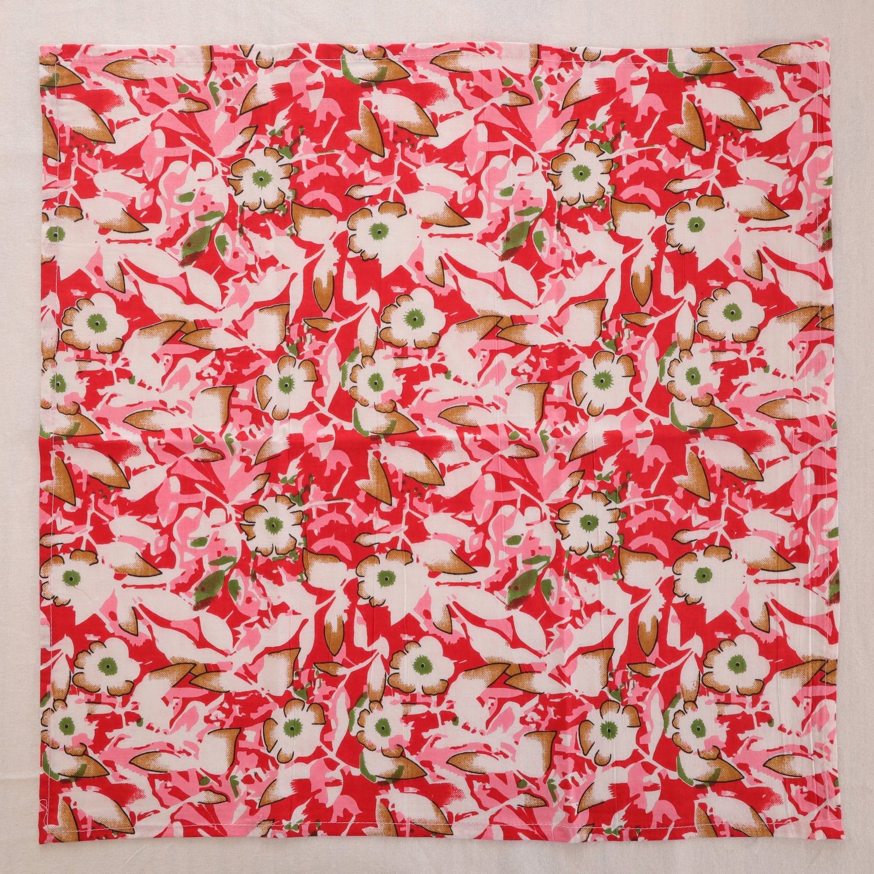 Red and cream hand block print cotton napkin laid flat, full print visible