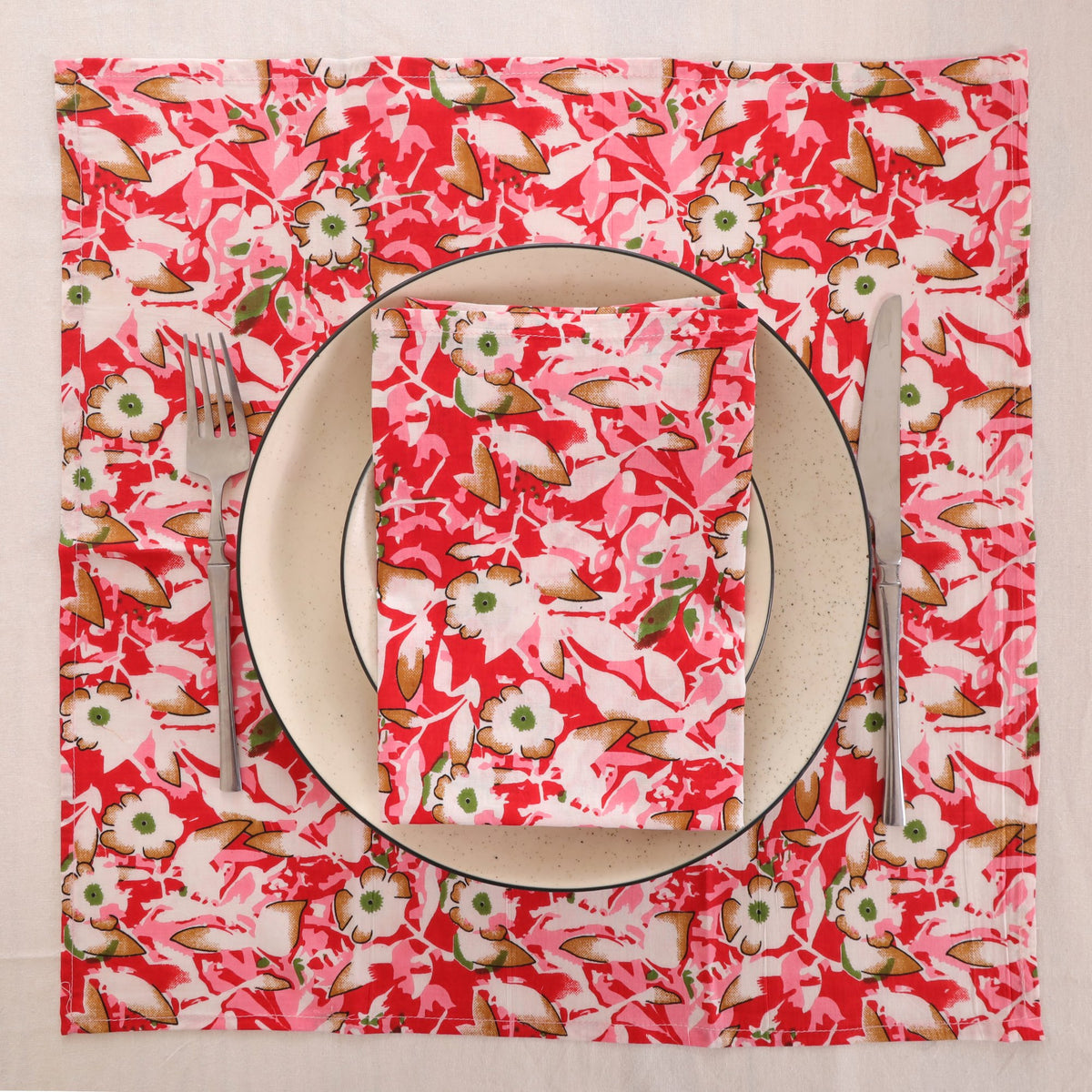 Red and cream block print napkin set as a place setting with plate and cutlery