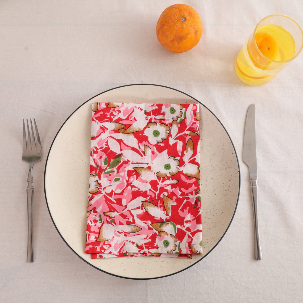 Red and cream block print cotton napkin folded on a dinner plate