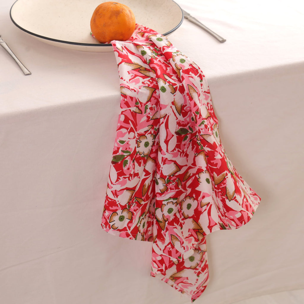 Red and cream block print napkin draped over the edge of a table