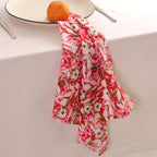 Red and cream block print napkin draped over the edge of a table