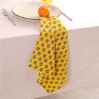 Yellow buti block print napkin draped over the edge of a table