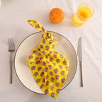 Yellow buti block print cotton napkin knotted on a plate