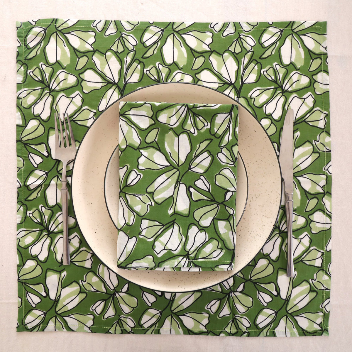 Green and white block print napkin set as a place setting with plate and cutlery