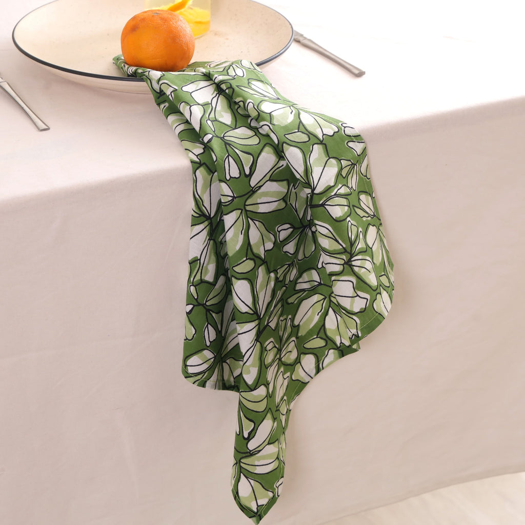 Green and white block print napkin draped over the edge of a table