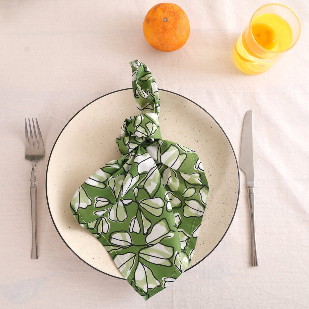 Green and white block print cotton napkin knotted on a plate