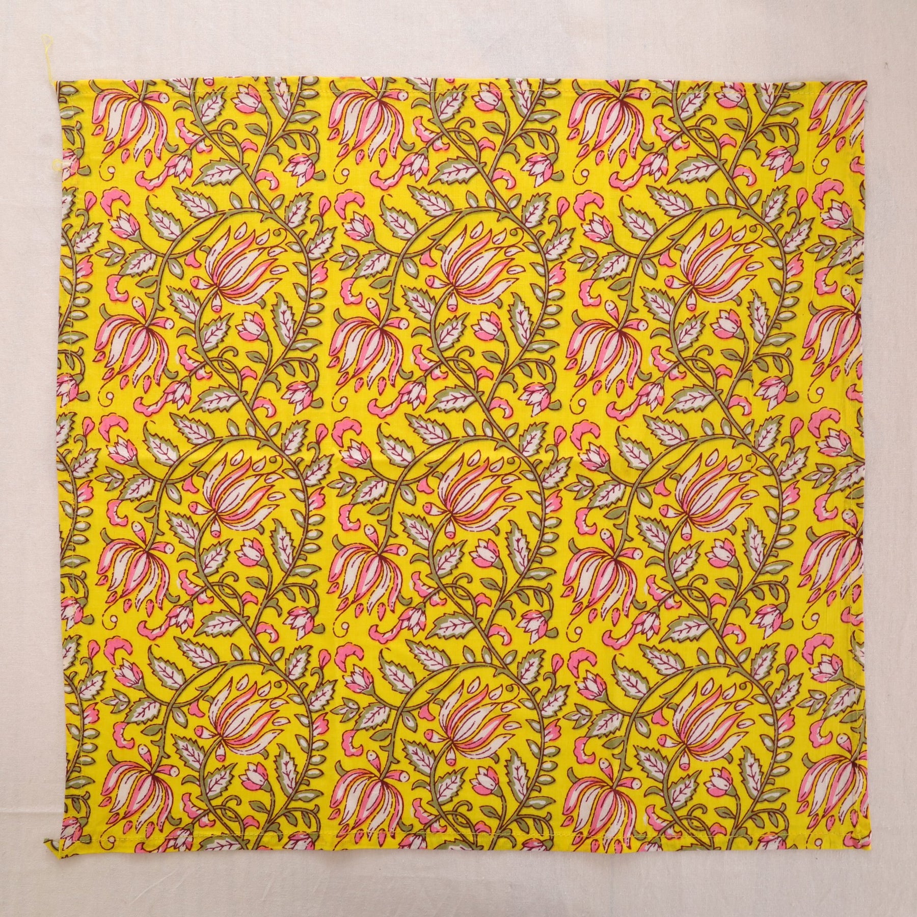 Yellow and pink paisley hand block print cotton napkin laid flat, full print visible