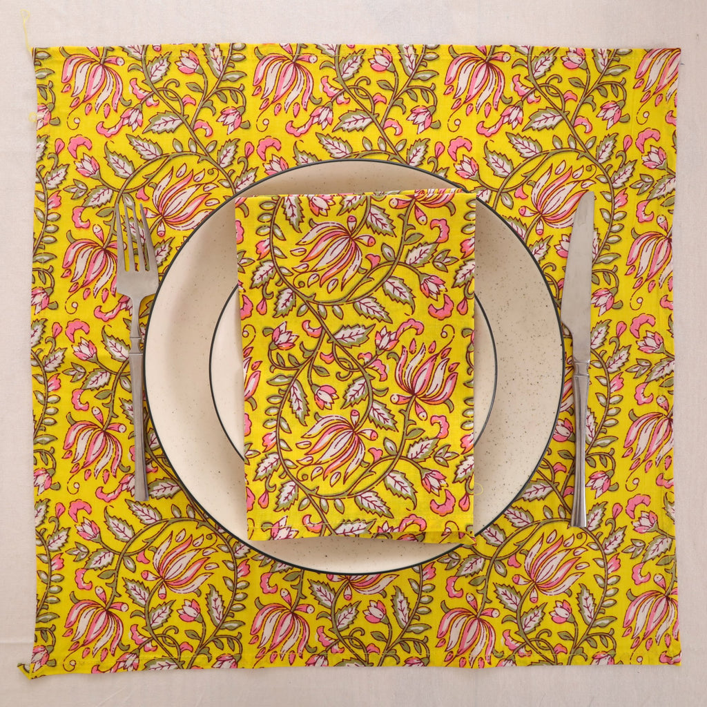Yellow and pink paisley block print napkin set as a place setting with plate and cutlery