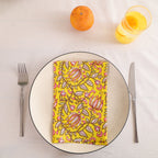 Yellow and pink paisley block print cotton napkin folded on a dinner plate