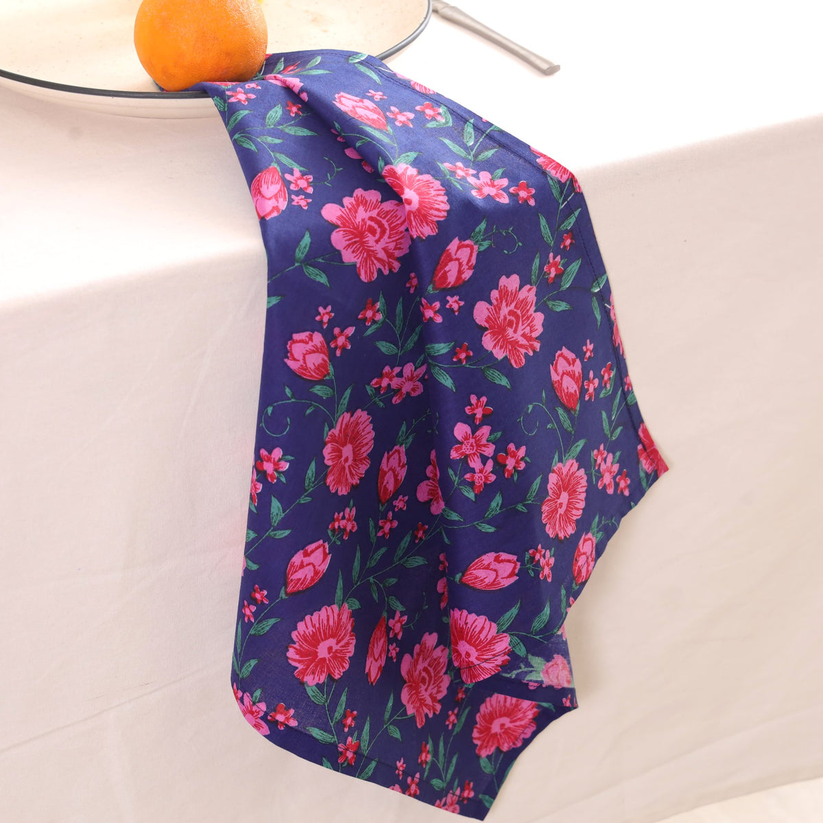 Navy and pink block print napkin draped over the edge of a table